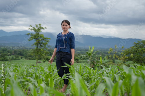 A local woman stands in a cornfield in the dark rainy season.