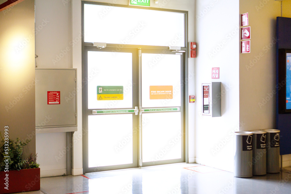 Exit sign and fire extinguisher at building.. Exit sign and fire extinguisher at building..