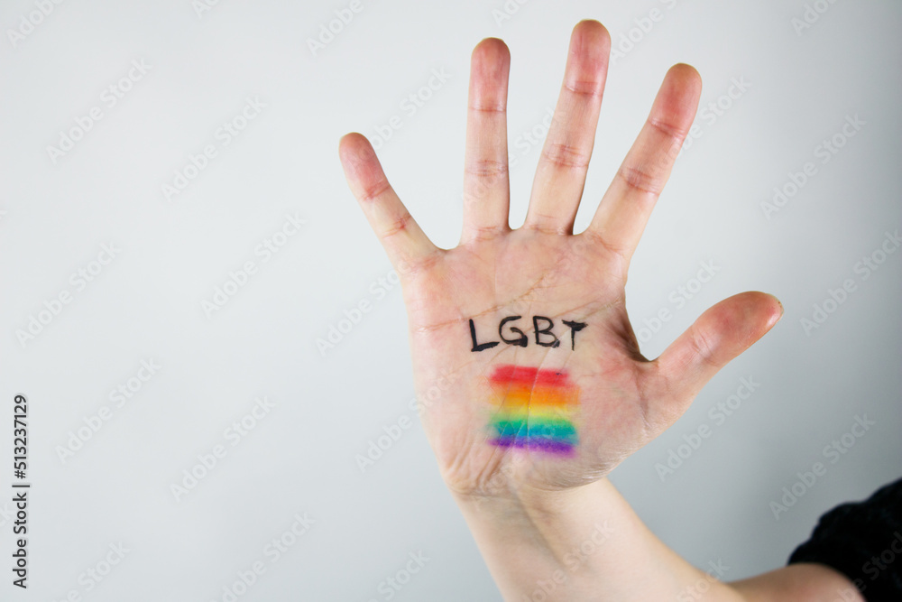 hand with lgbt community design and flag with its rainbow colors on white background hand with lgbt community design and flag with its rainbow colors on white background