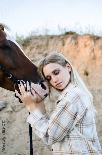 Portrait of a beautiful young woman with a horse close-up vertical. Pleasure, love and care for animals © Olga Kravchenko
