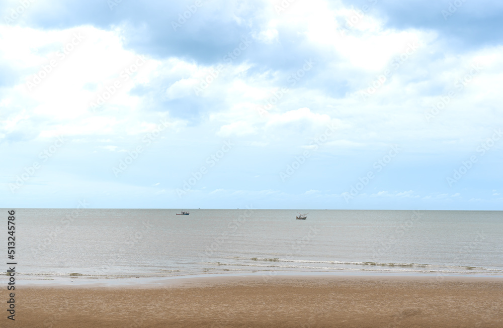 The sand beach,sea,fishing boats and soft sky background.