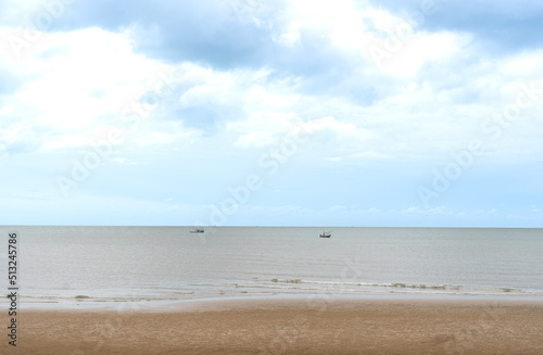 The sand beach sea fishing boats and soft sky background.