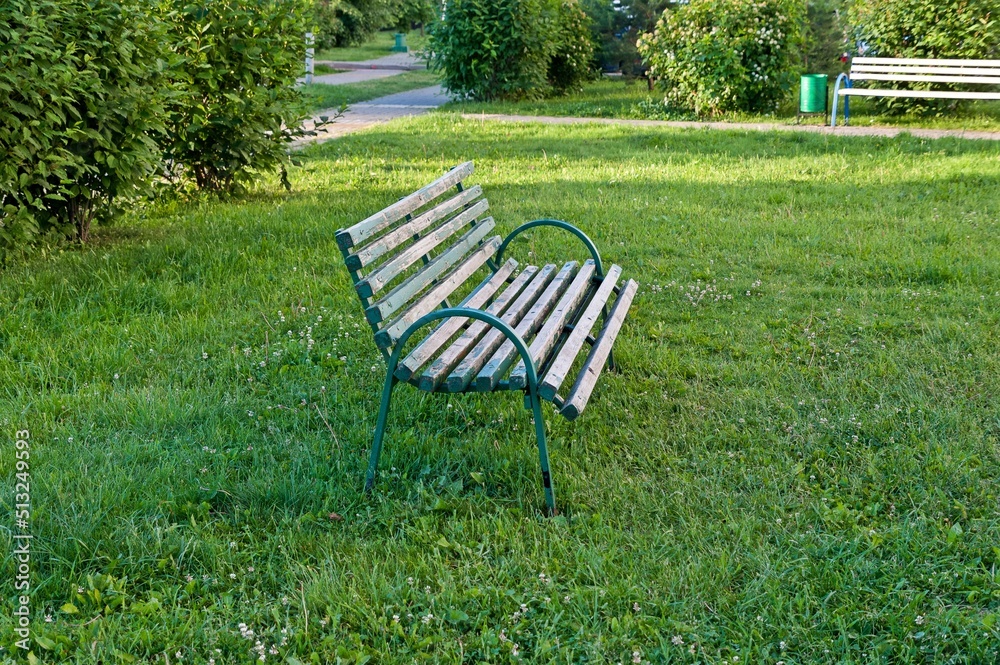 The bench stands on the grass of the lawn The bench stands on the grass of the lawn