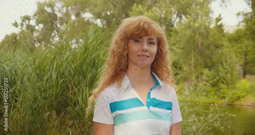 A happy blonde woman at sunset, dancing and singing in the park. The concept of the holiday