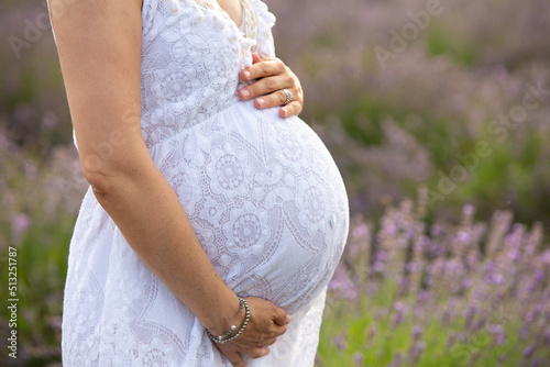 Belly of a pregnant woman in a lavender field
