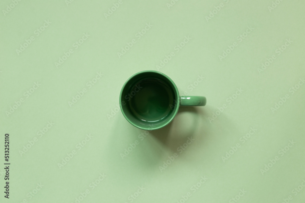 Empty mug cup on green background. top view, copy space