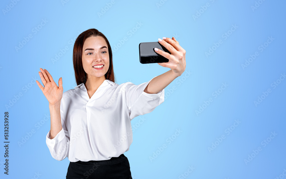 Businesswoman with phone in hand, waving on blue background. Copy space Businesswoman with phone in hand, waving on blue background. Copy space