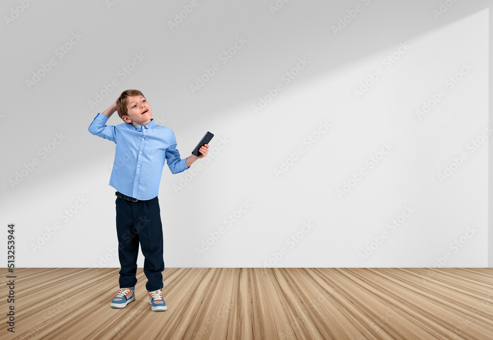 Boy with phone in hand, thinking on white background. Copy space