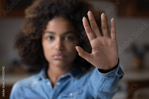 Close up focus African woman show palm hand opposes racial or gender discrimination, make stop gesture, sign of protest, female against domestic violence, abortion, bullying at school, say no concept photo