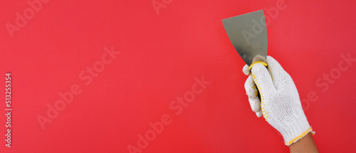 Принти на полотні hand wearing white gloves holding putty knife scraper isolated red background