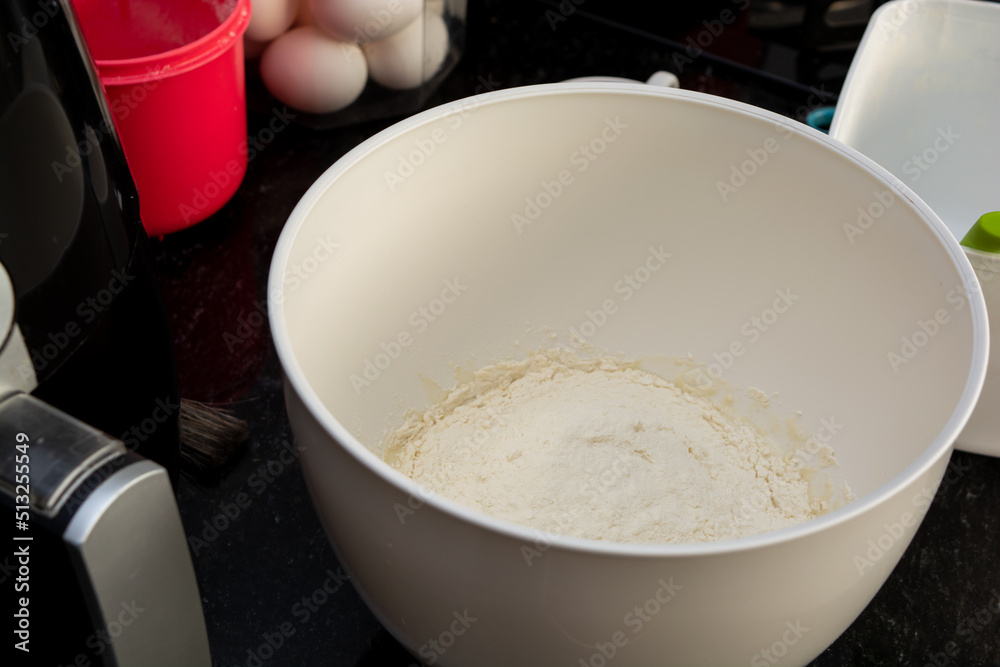flour inside a mixer in a black marble surface. preparing family snack flour inside a mixer in a black marble surface. preparing family snack