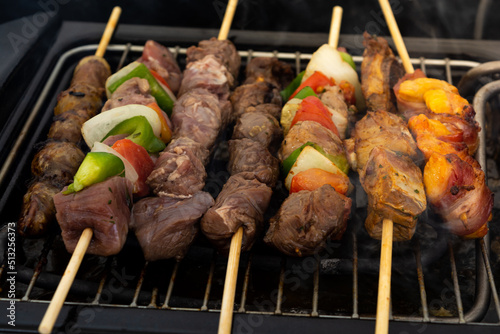 seven skewers on an electric grill, made of pork, chicken, onion, pepper, bovine photo