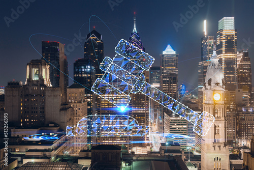 Aerial panoramic cityscape of Philadelphia financial downtown at night time, Pennsylvania, USA. Glowing hologram of legal icons. The concept of law, order, regulations and digital justice.