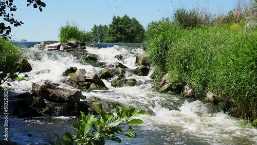 Fast flowing water in the mountain river, water spray from the waves. Texture of seething water, a cascade of a mountain river, bubbles and foam in a stream of water.