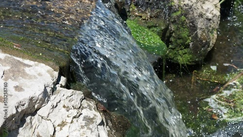Fast flowing water in the mountain river, water spray from the waves. Texture of seething water, a cascade of a mountain river, bubbles and foam in a stream of water.