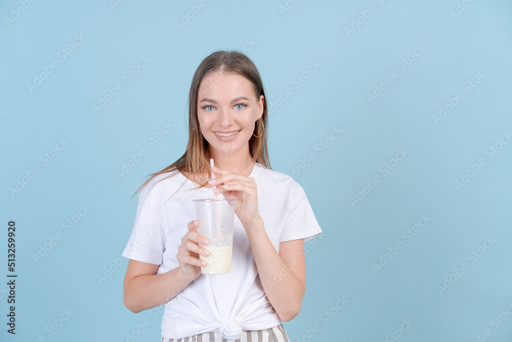 Follow me followers. Concept social influence. Close up studio photo portrait hipster carefree girl holding cocktail in her hand, wearing light clothes isolated blue pastel background Follow me followers. Concept social influence. Close up studio photo portrait hipster carefree girl holding cocktail in her hand, wearing light clothes isolated blue pastel background