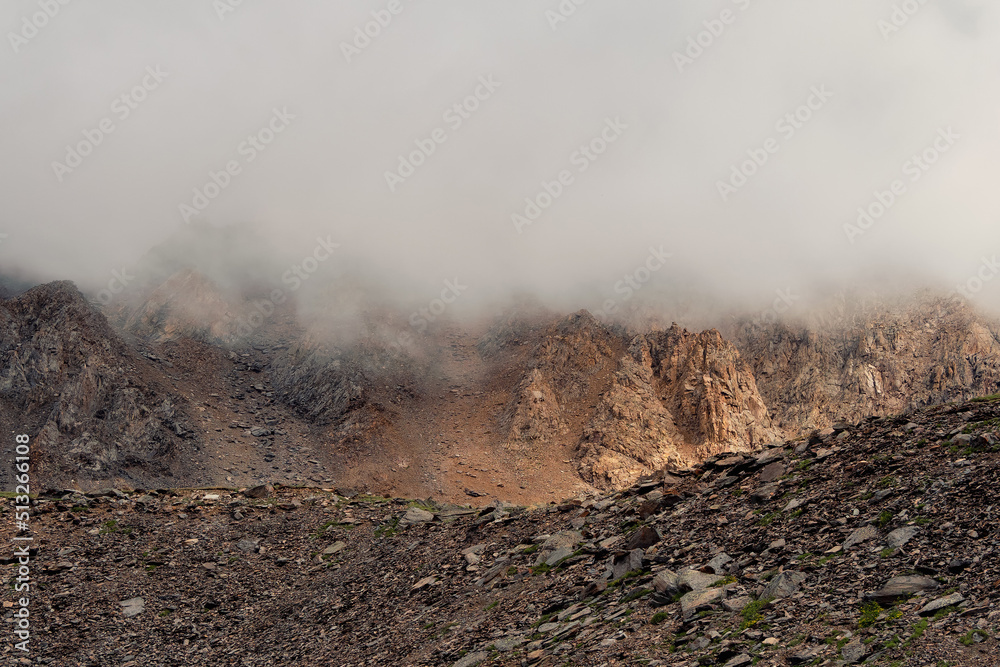 Mountains in a dense fog. Mystical landscape with beautiful shar