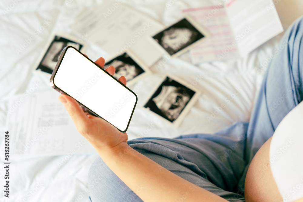 Pregnancy smartphone mockup. Pregnant woman holding smartphone. Mobile pregnancy online maternity application mock up. Concept of pregnancy, maternity, expectation for baby birth. Pregnancy smartphone mockup. Pregnant woman holding smartphone. Mobile pregnancy online maternity application mock up. Concept of pregnancy, maternity, expectation for baby birth.
