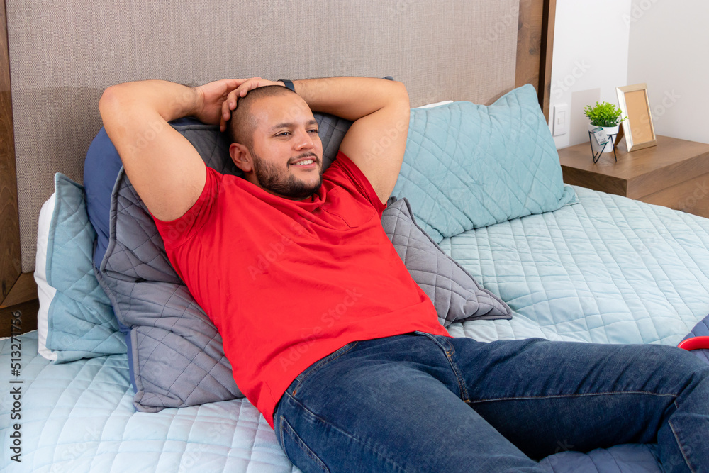 Young latin man on the bed rejanadose while watching tv Young latin man on the bed rejanadose while watching tv