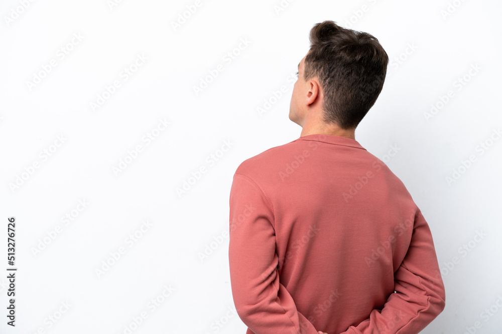 Young handsome Brazilian man isolated on white background in back position and looking back Young handsome Brazilian man isolated on white background in back position and looking back
