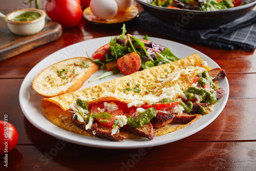 Pesto Chicken omelette roll with salad served in a dish isolated on wooden background side view