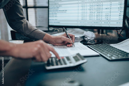 Investors working on desk office and using a pan and pointing to check tracking cost, balance, profit and  currency. Accounting and  Financial concept.