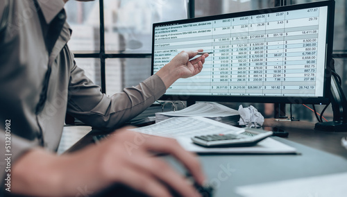 Obraz na płótnie Investors working on desk office and use computer  to check data cost, balance, profit and  currency