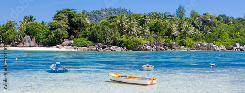 Boat on the shore of a tropical island. Pleasure boat moored on the shore of the resort. Beautiful tropical landscape of the Seychelles.