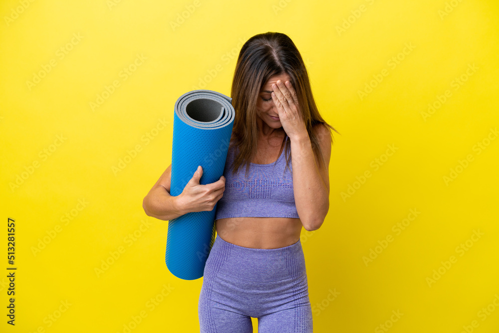 Sport woman going to yoga classes while holding a mat isolated non yellow background with tired and sick expression Sport woman going to yoga classes while holding a mat isolated non yellow background with tired and sick expression