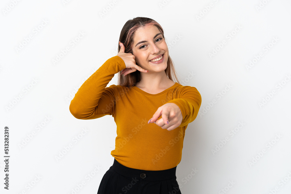 Young caucasian woman isolated on white background making phone gesture and pointing front Young caucasian woman isolated on white background making phone gesture and pointing front