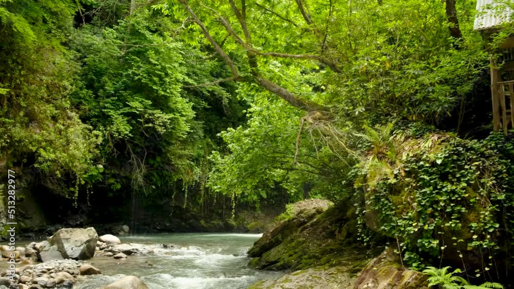 Wild mountain river landscape with a wooden gazebo. Rapid clean flow. Gorgeous view of stream of water flowing between river banks. Wild mountain river landscape with a wooden gazebo. Rapid clean flow. Gorgeous view of stream of water flowing between river banks.
