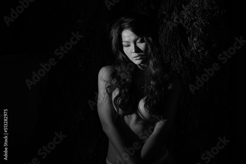 Low key sexy portrait showing body in black and white.