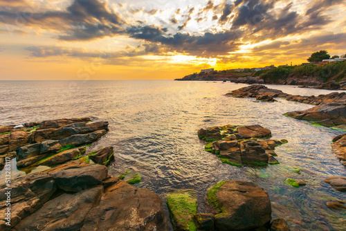 gorgeous sunrise at the sea. rocky seashore and clouds in morning light. stunning view. summer vacations and weather change concept © Pellinni