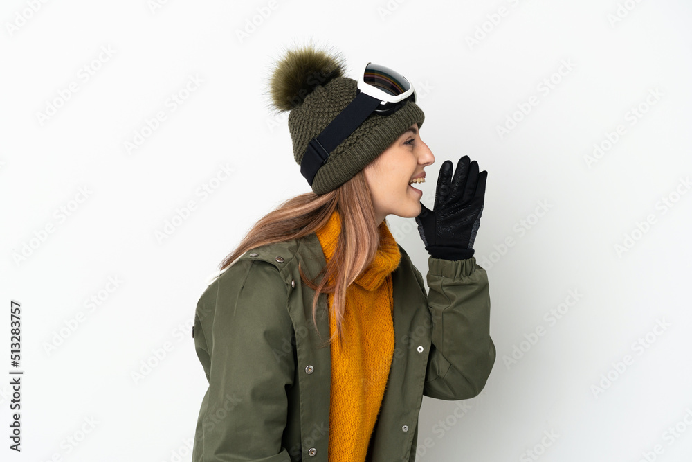 Skier caucasian woman with snowboarding glasses isolated on white background shouting with mouth wide open to the side Skier caucasian woman with snowboarding glasses isolated on white background shouting with mouth wide open to the side