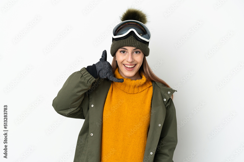 Skier caucasian woman with snowboarding glasses isolated on white background making phone gesture. Call me back sign