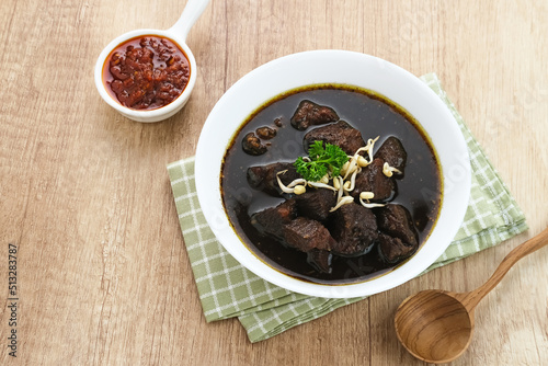 Rawon  Indonesian Traditional beef black soup. Served on a bowl with mung bean sprouts  chilli paste and salted egg 