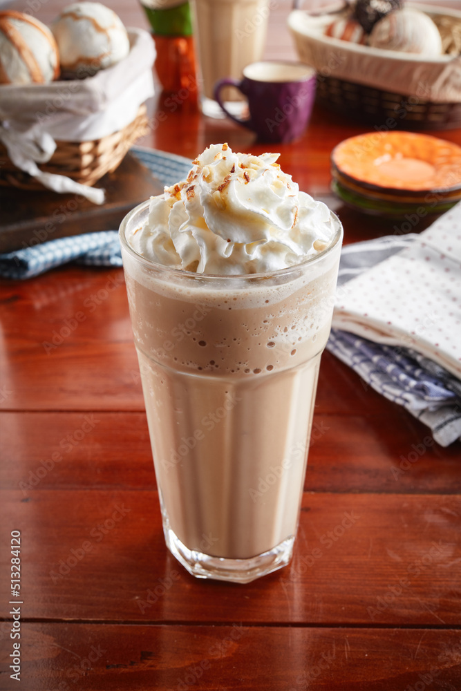 A glass of healthy fresh TOFFEENUT FRAPPE isolated on wooden background side view A glass of healthy fresh TOFFEENUT FRAPPE isolated on wooden background side view