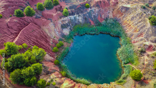 The lake in old bauxite's red soils quarry cave in Apulia, Otranto, Salento, Italy. The digging was filled with natural waters