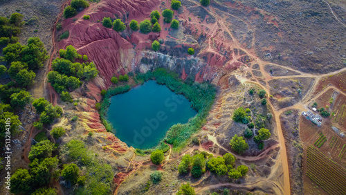 The lake in old bauxite's red soils quarry cave in Apulia, Otranto, Salento, Italy. The digging was filled with natural waters