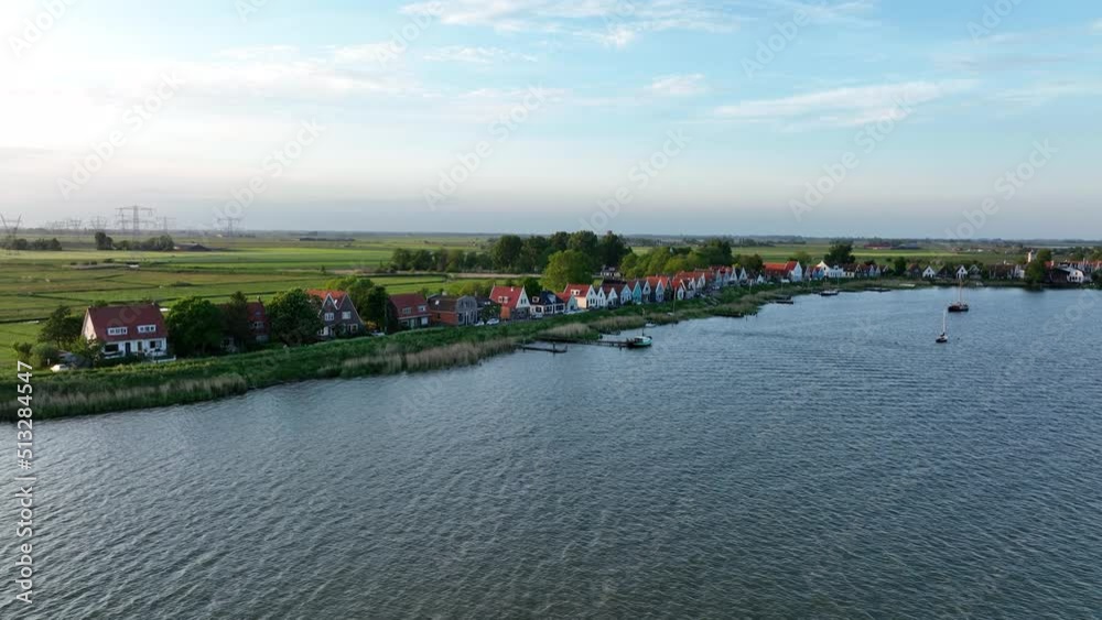 Durgerdam local dyke village with old traditional wooden houses in the north of Amsterdam. Harbour maritime countryside aerial landscape at sunset. Dutch Holland landscape.