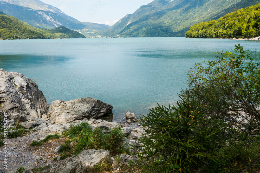 View of Molveno lake in The Adamello - Brenta nature Park. The lake is located at the shore of Molveno at the foot Brenta Dolomites group, a popular summer e winter tourists vacation resort - Italy View of Molveno lake in The Adamello - Brenta nature Park. The lake is located at the shore of Molveno at the foot Brenta Dolomites group, a popular summer e winter tourists vacation resort - Italy