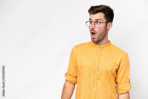 Young caucasian man isolated on white background doing surprise gesture while looking to the side © luismolinero
