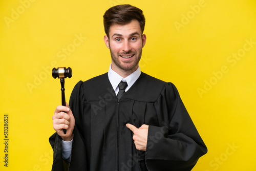 Judge caucasian man isolated on yellow background with surprise facial expression