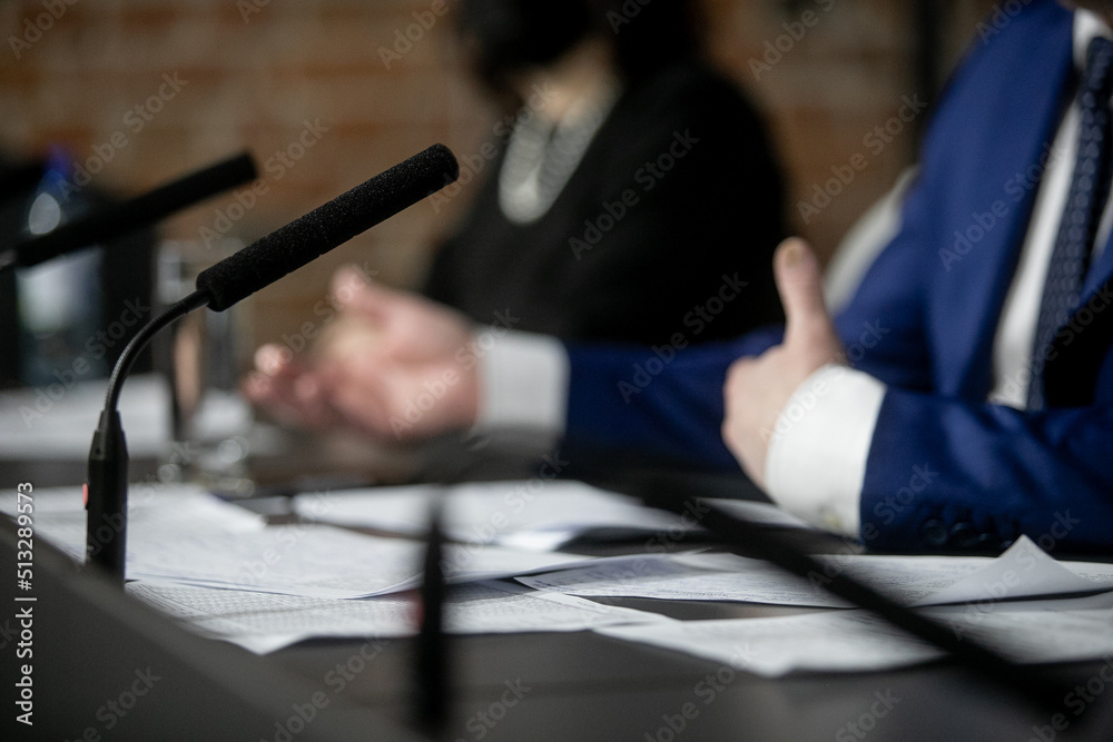 Fototapeta premium A man in a business suit is holding a pen. There are notebooks on the table