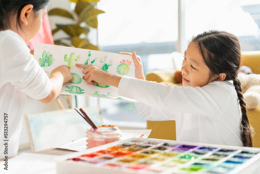 beautiful young child look, point to painting on paper art for little kid. asian beautiful children happy and fun color painting education in small school beautiful young child look, point to painting on paper art for little kid. asian beautiful children happy and fun color painting education in small school