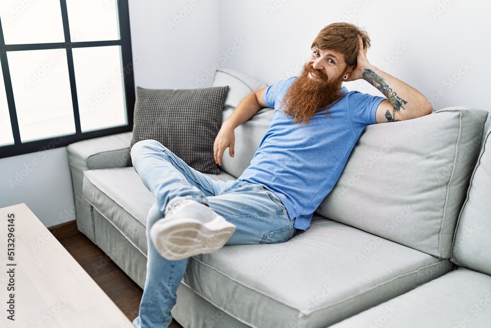 Fototapeta premium Young irish man smiling happy sitting on the sofa at home.