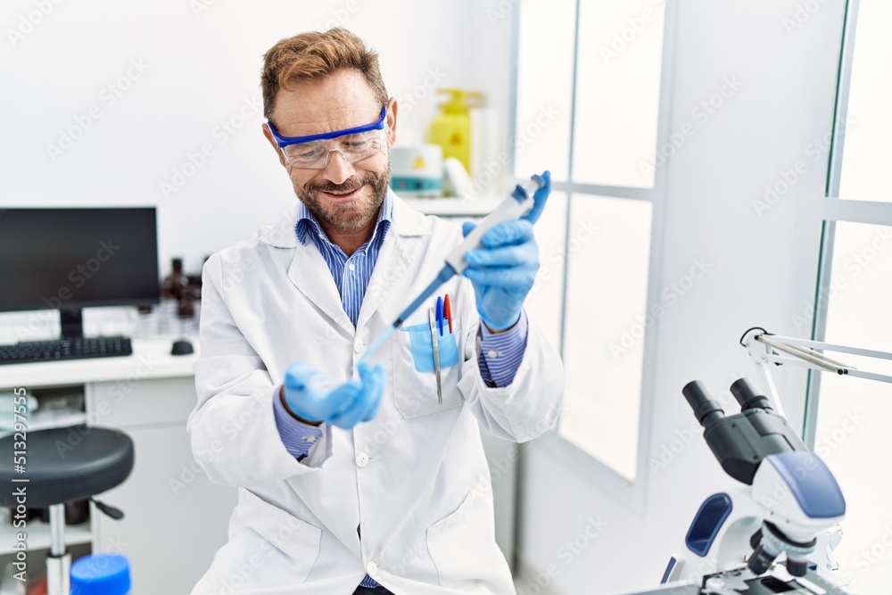 Middle age hispanic man wearing scientist uniform working at laboratory