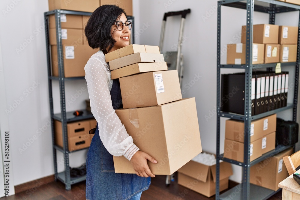 Young latin woman ecommerce business worker holding packages order at office Young latin woman ecommerce business worker holding packages order at office