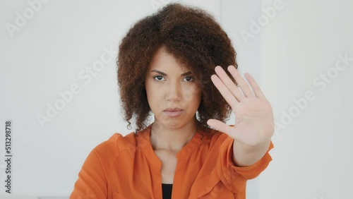 Female headshot serious angry sad frustrated african american girl biracial woman holding hand in front forbidden no stop enough gesture refusal keep distance sign refuse prohibits limitation palm photo