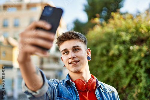 Young caucasian guy smiling taking a selfie picture at the city